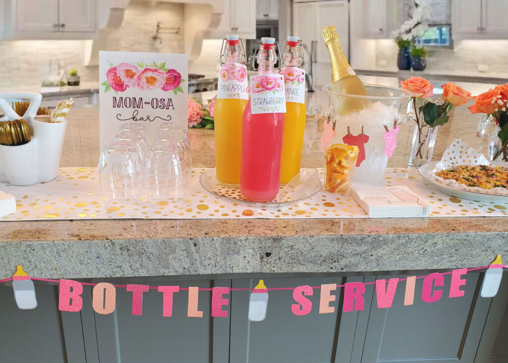 Mimosa bar and batch cocktails displayed with custom drink menu signage and themed glassware.