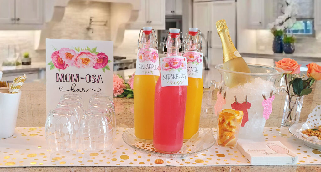 Mimosa bar and batch cocktails displayed with custom drink menu signage and themed glassware.