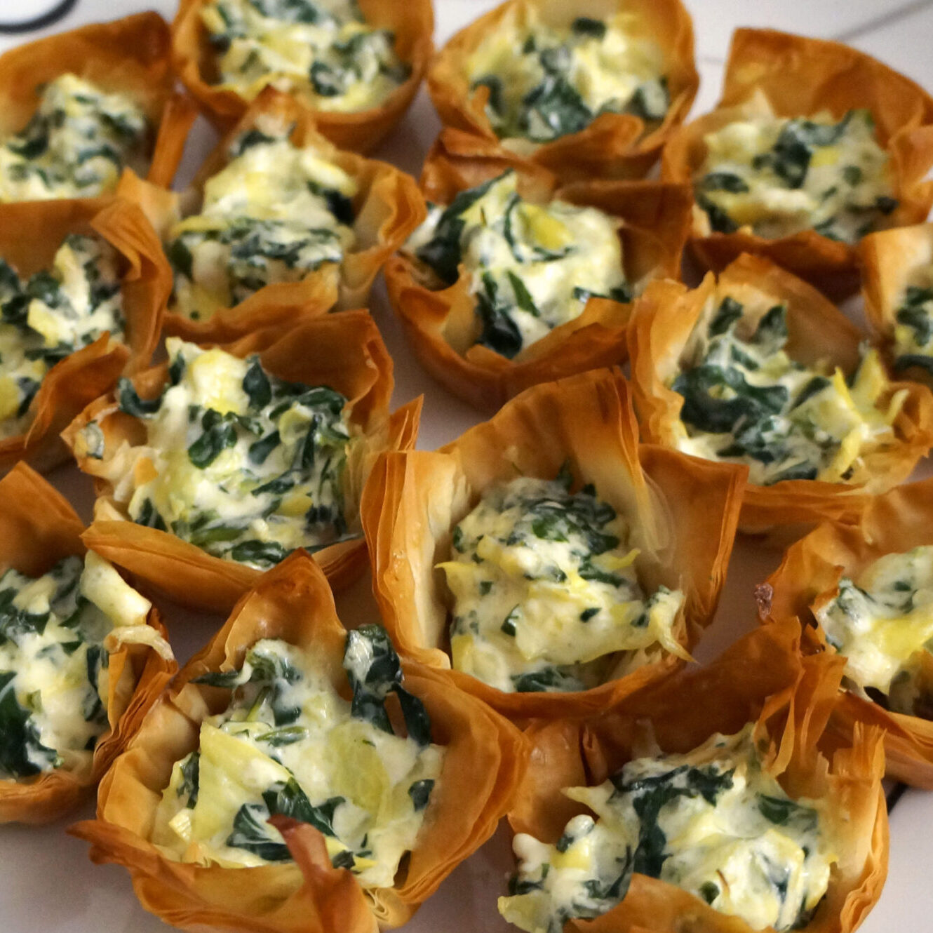 Baked spinach and artichoke dip served in crisp phyllo shells as an easy finger food appetizer.