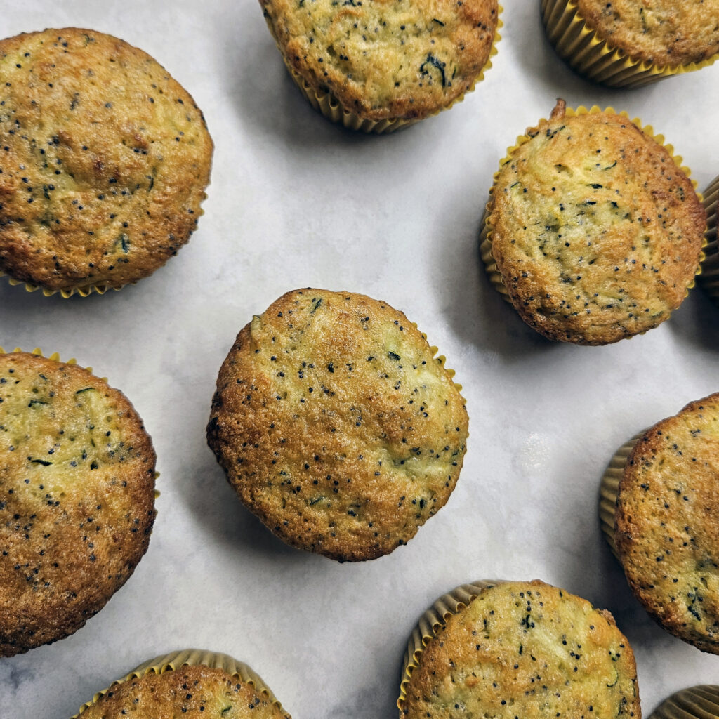 Close-up of lemon poppy seed squash muffins showing a soft crumb and poppy seed texture.