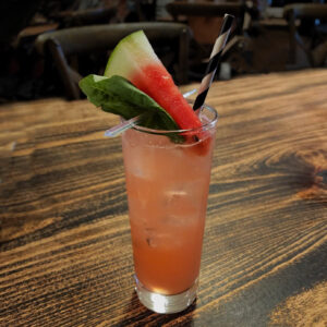 Fresh watermelon basil gimlet served in a clear glass with basil garnish.
