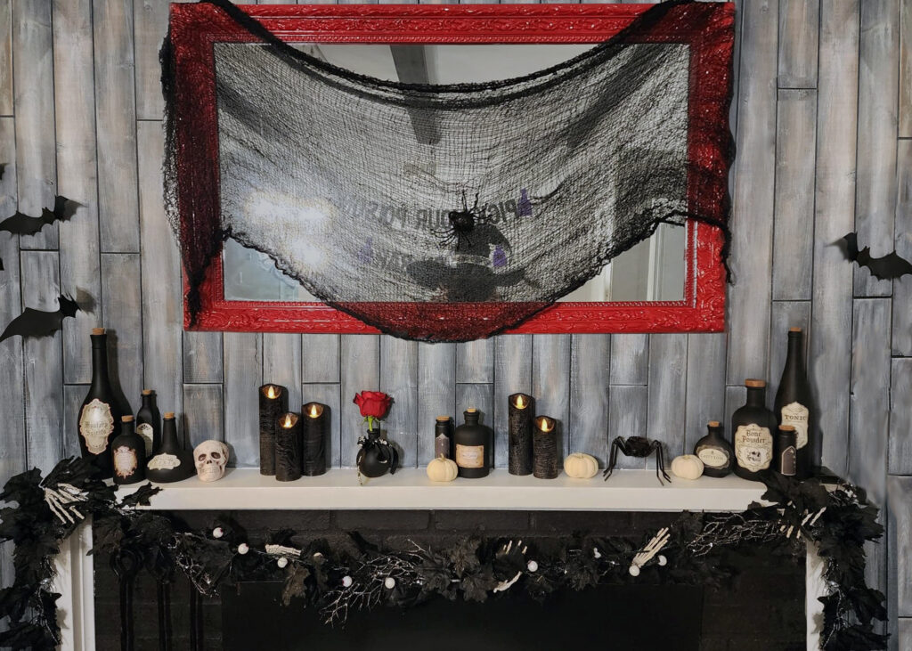 Black Magic Halloween party mantle decorated with potion bottles, candles, and dark witchy accents.
