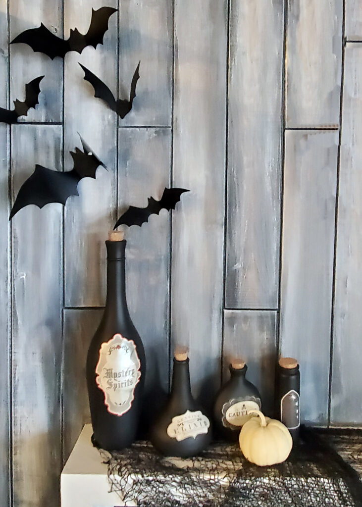 Black Magic Halloween party mantle decorated with potion bottles, candles, and dark witchy accents.
