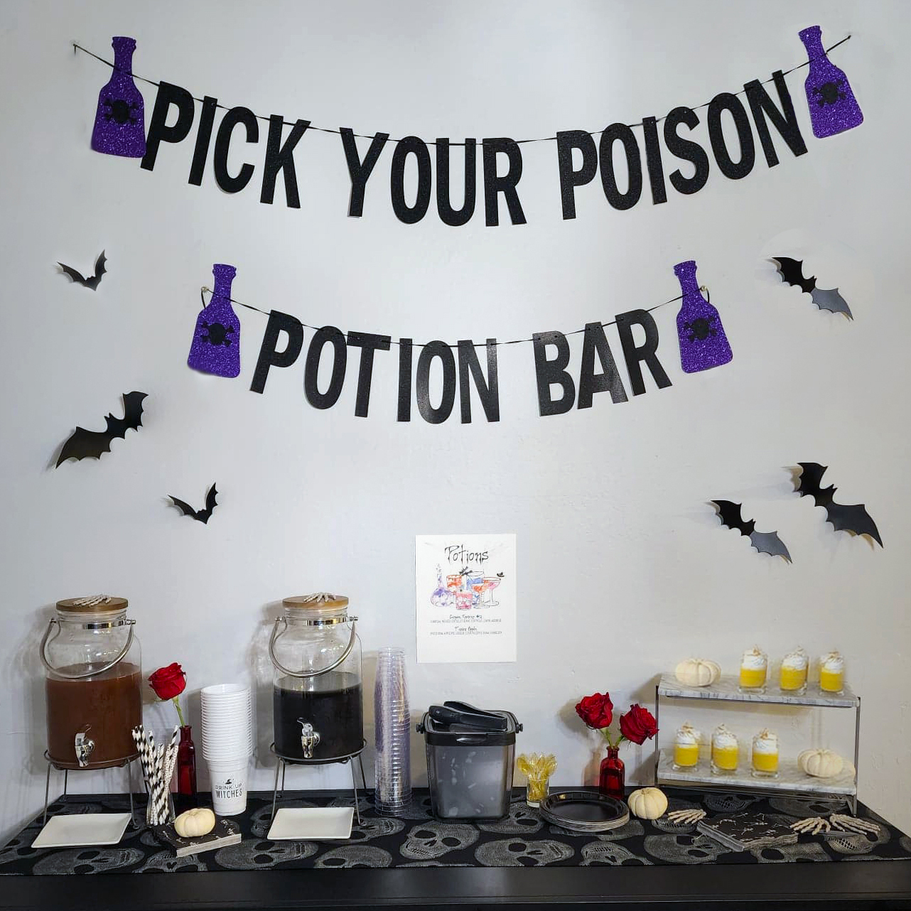Black Magic Halloween potion bar with themed cocktails, skull glassware, and custom drink menu.