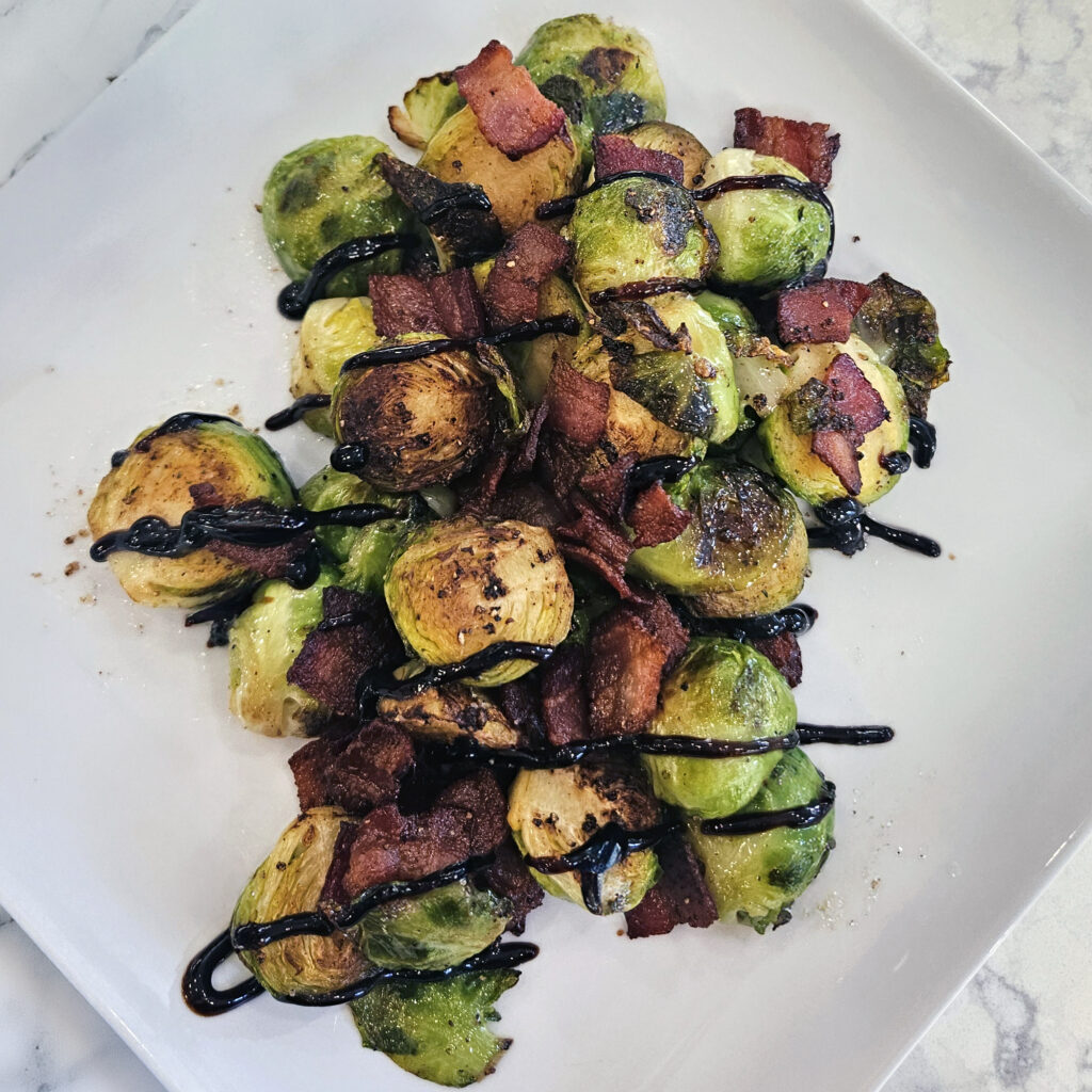 Finished Brussels sprouts tossed with crispy bacon, honey, and balsamic vinegar