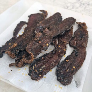 Close-up of crisp edges and caramelized sugar bubbling on baked bacon.