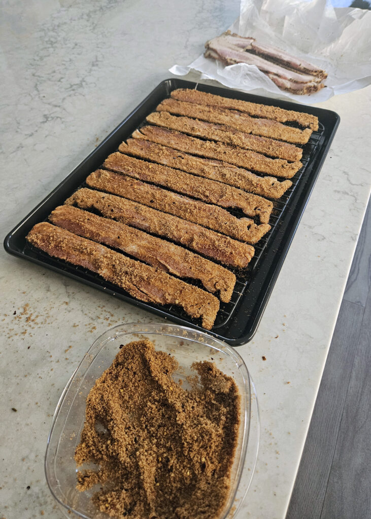 Thick-cut bacon coated in brown sugar and smoky spices before baking.