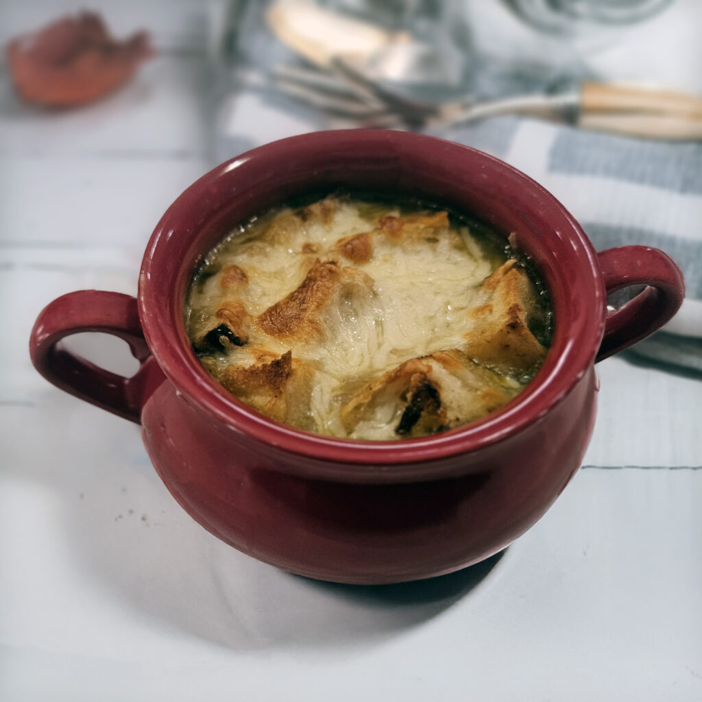 Finished soup topped with toasted baguette slices and melted cheese.