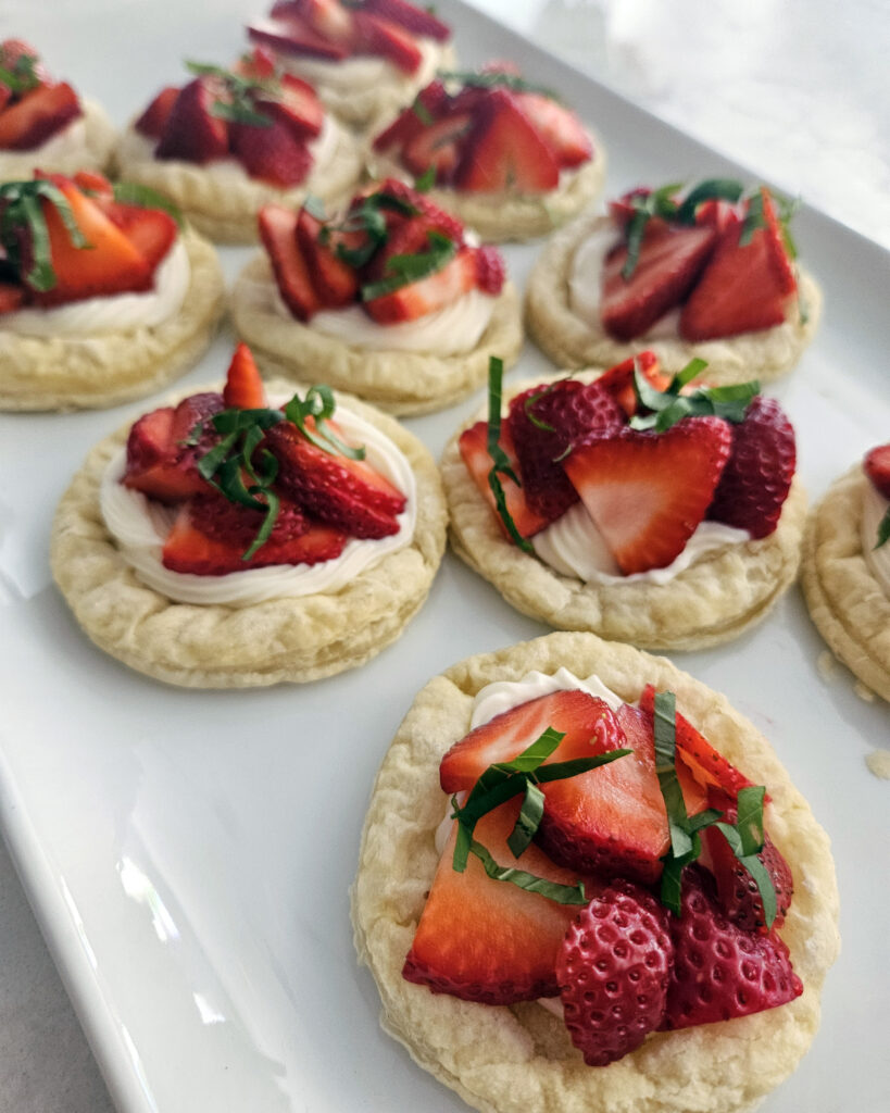 Flaky puff pastry rounds filled with cream cheese and fresh strawberries, baked until golden.