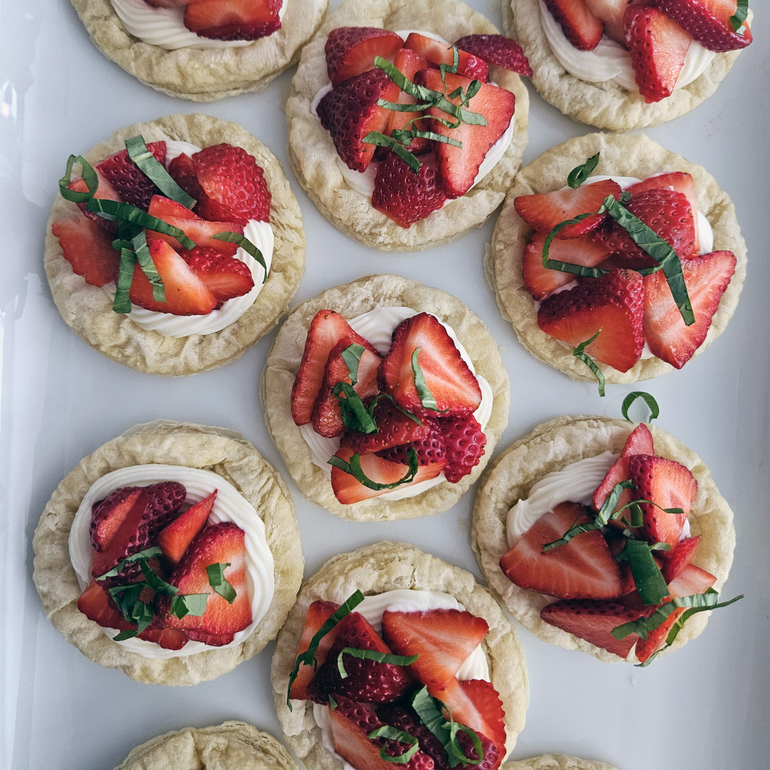 Flaky puff pastry rounds filled with cream cheese and fresh strawberries, baked until golden.