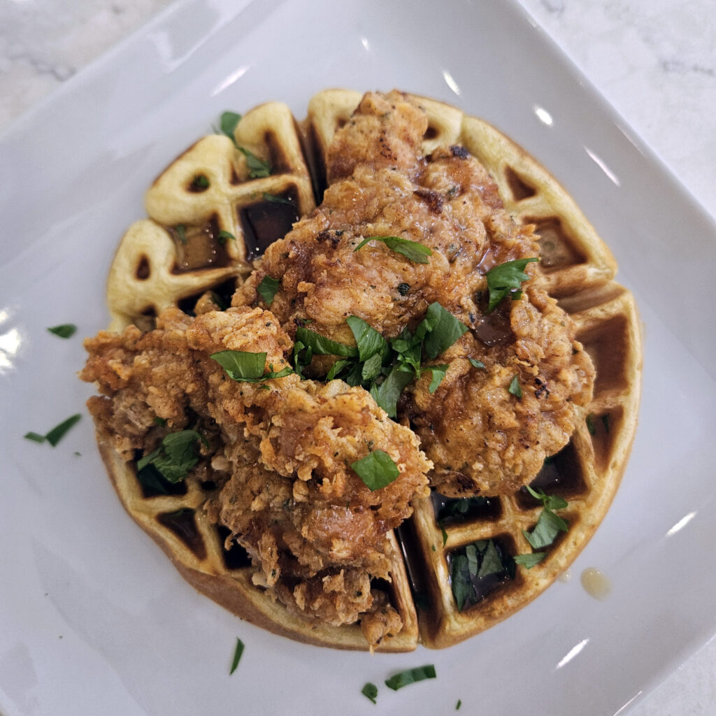Plated chicken and waffles served hot and ready for brunch.