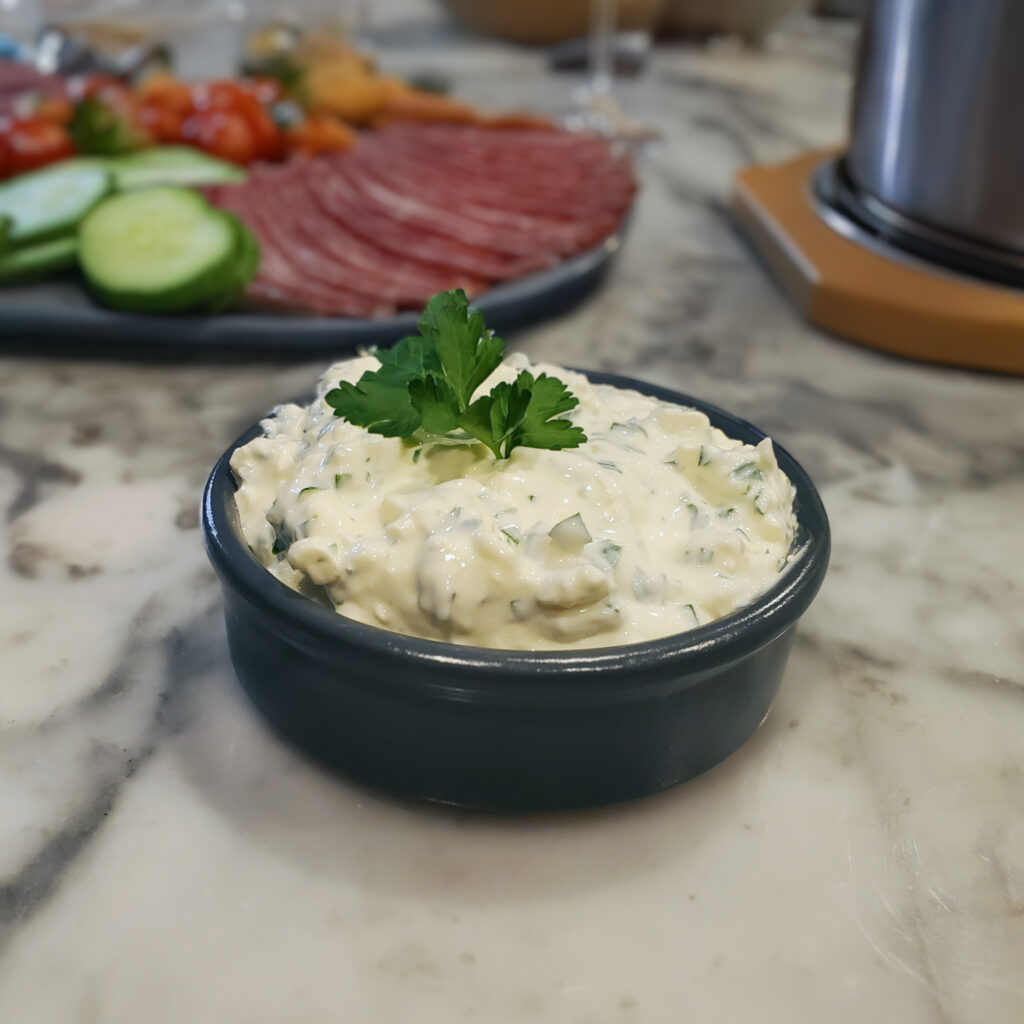 Green Goddess dip served alongside a colorful platter of fresh vegetables for dipping.