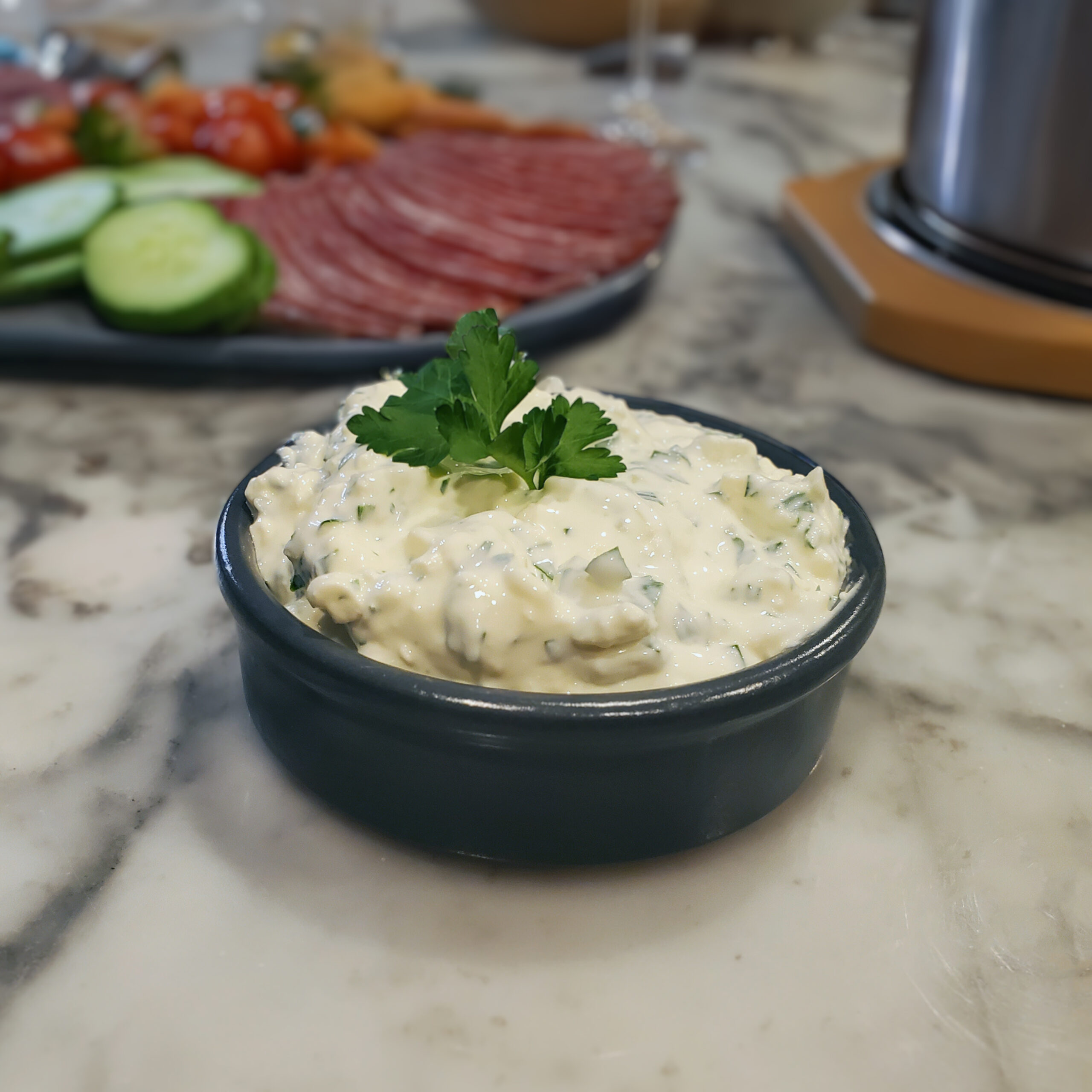 Green Goddess dip served alongside a colorful platter of fresh vegetables for dipping.