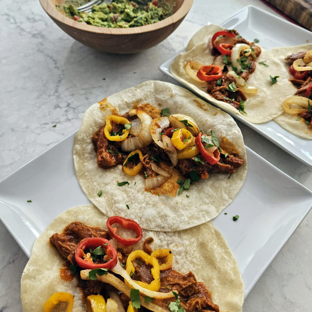 Shredded chicken coated in mole rojo served in flour tortillas with grilled vegetables.