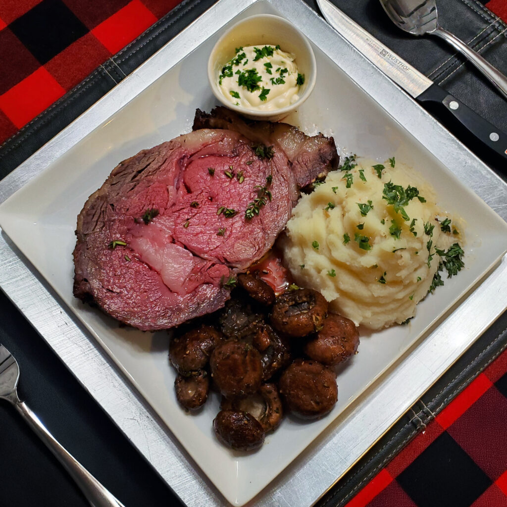 Prime rib dinner plate – Christmas dinner plate with sliced prime rib, mashed potatoes, mushrooms, and creamy horseradish sauce.