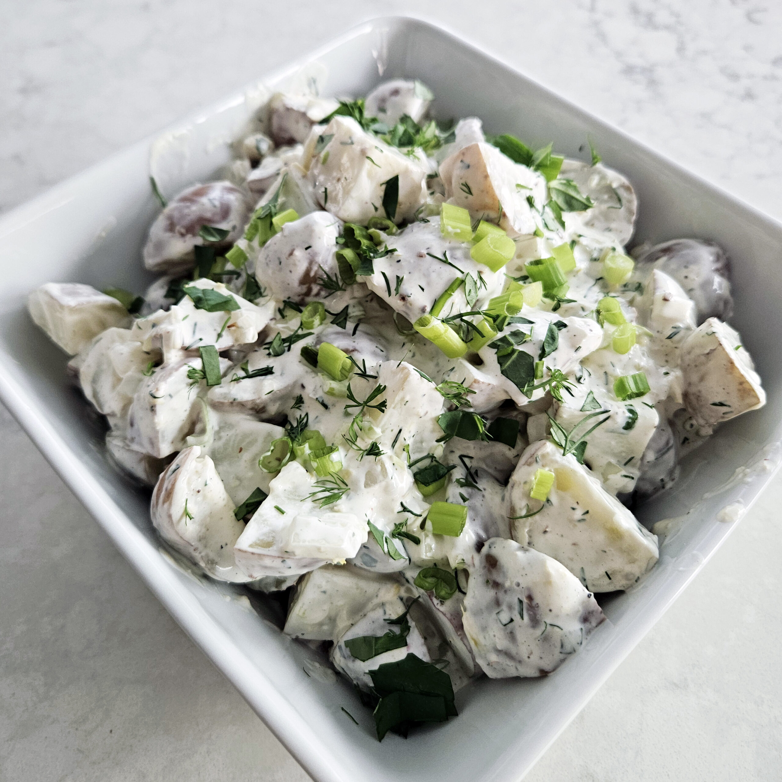 Creamy potato salad served as a side dish for a summer luau pool party.