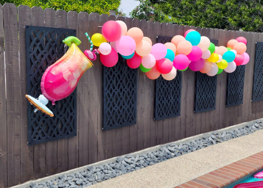 Tropical balloon garland in bright colors used as decor for a luau-themed pool party.