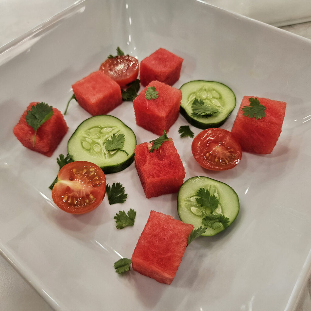 Bowl filled with fresh watermelon cubes and sliced cucumber, prepped and ready to be added to the Spicy Watermelon Gazpacho before pouring in the chilled soup base.