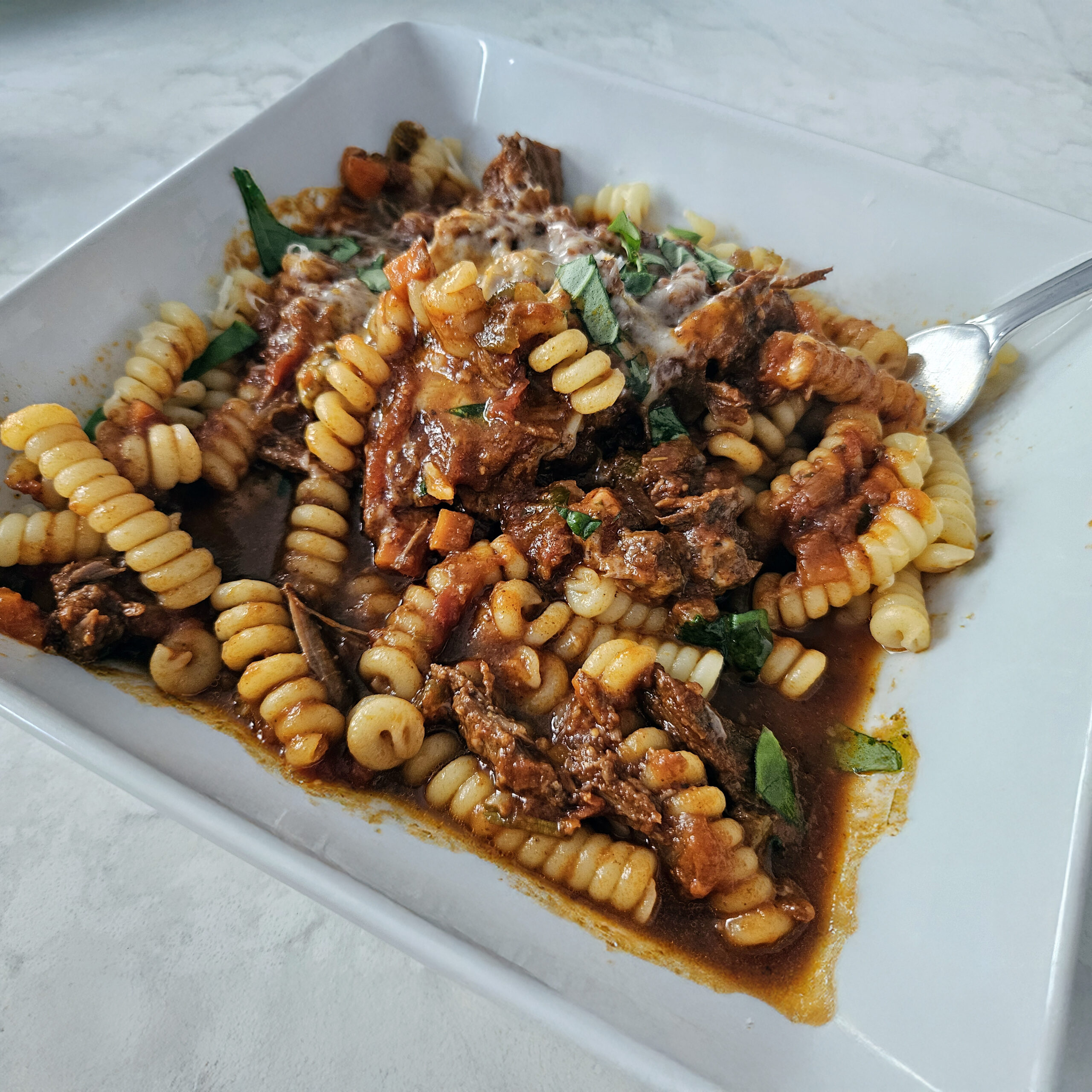 Slow-simmered short rib ragù made with red wine, tomatoes, and herbs, finished with wide pasta for a rich, comforting Italian-style dinner.